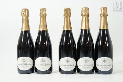 quatre bouteilles de champagne sont alignées sur une surface blanche