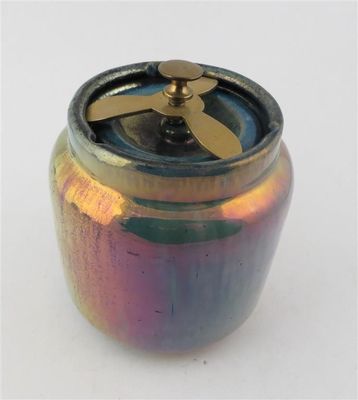 a small jar with a fan on top of it