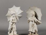 pair of white porcelain figurines of children with umbrellas