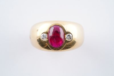 une image représentant une bague en or sertie d'un rubis et de deux diamants