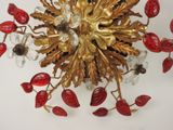 a gold and red chandelier with flowers and leaves