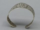 a close up of a silver bracelet with a flower design on it
