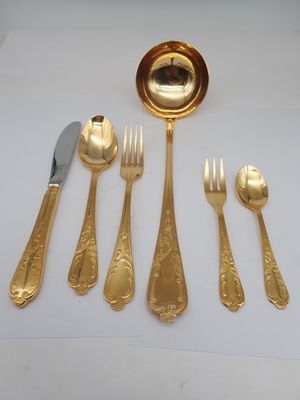 a gold plate with a spoon, fork, and knife on it