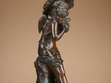 bronze statue of a woman with an umbrella on a pedestal