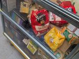 a glass display case filled with food on the sidewalk