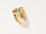 a gold ring with emerald stones and diamonds