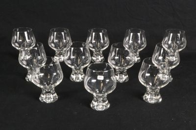 six clear wine glasses are lined up on a black surface
