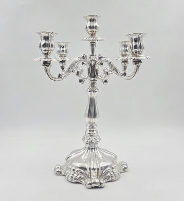 a silver candelier with three candles on a white background