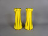deux vases jaunes posés l'un à côté de l'autre sur une table