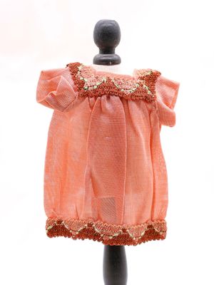 une robe rose posée sur un mannequin noir, sur fond blanc
