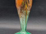 a glass vase with a flower in it sitting on a table