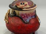 a small red pot with a lid on a table