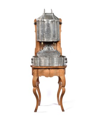 a metal pot on a wooden stand with a white background