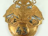 an image of a gold plate with an eagle and a shield with the number thirteen on it