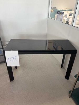 une table en verre sur laquelle est posé un panneau, dans une pièce