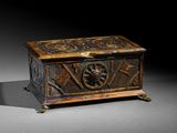 une vieille boîte en bois ornée de sculptures, posée sur une table