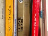 several books are lined up on a shelf in a library