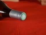 a bottle of wine sitting on a red table cloth