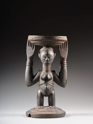statue d'une femme tenant un bol sur la tête