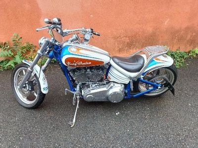 une moto bleue et blanche garée devant un mur rouge