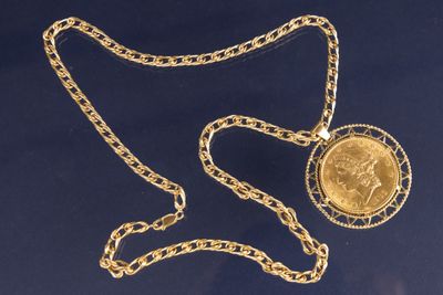 collier composé d'une pièce d'or suspendue à une chaîne, elle-même entourée d'une autre chaîne