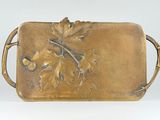 a metal tray with a leaf design on it