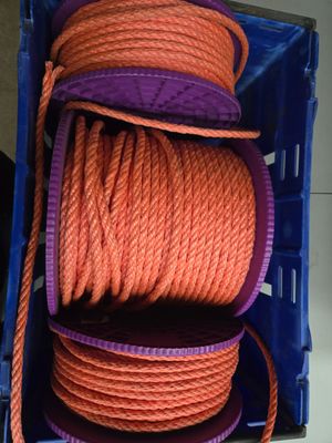 une corde orange dans une caisse bleue munie d'une poignée violette