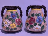 deux vases décorés de fleurs, placés l'un à côté de l'autre