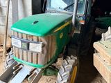 a green tractor that is parked in a barn