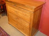 a wooden chest of drawers with a rug on the floor
