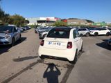 a white car parked in a parking lot with other cars
