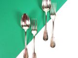 trois fourchettes et deux cuillères sur une table verte et blanche