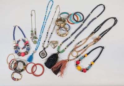 a lot of different necklaces and bracelets on the table
