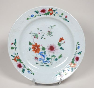 une assiette blanche décorée de fleurs et de feuilles colorées
