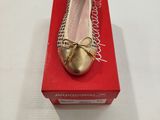 quelqu'un porte une paire de chaussures qui se trouvent sur une boîte rouge