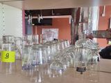 a man taking a picture of a counter full of wine glasses