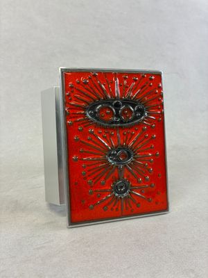 une broche argentée et rouge ornée d'une couronne