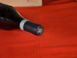 a bottle of wine sitting on a red table cloth
