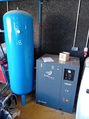 un réservoir bleu posé à côté d'une machine bleue dans une pièce