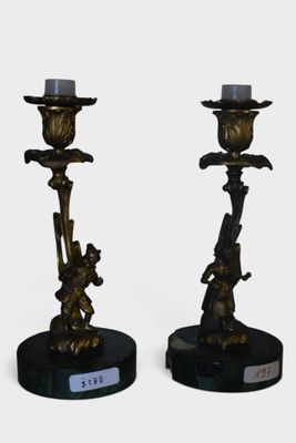 paire de bougeoirs anciens en laiton reposant sur des socles en marbre noir