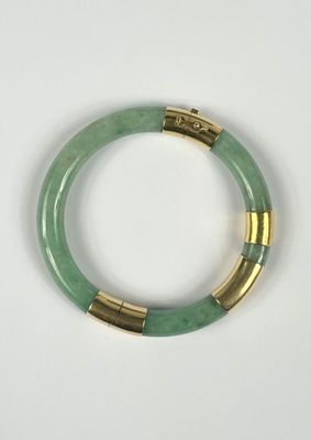 un gros plan d'un bracelet vert posé sur une surface blanche