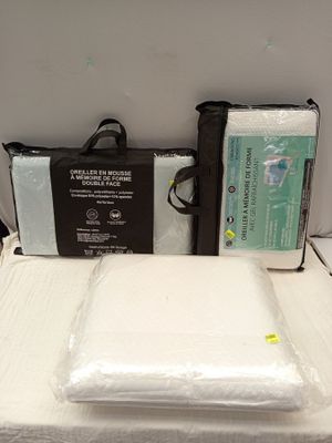 un lit avec deux oreillers et un sac posé dessus