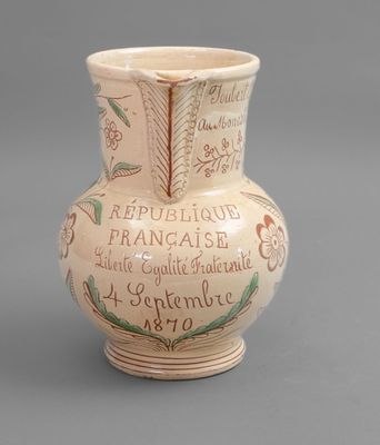 a small vase with writing on it sitting on a table