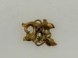 a gold brooch with a flower and leaves on it