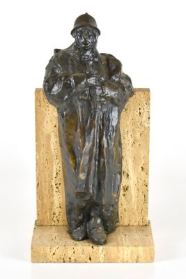 statue d'un homme assis sur un bloc de pierre, coiffé d'un chapeau