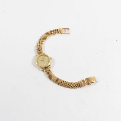 gros plan d'une montre en or sur une surface blanche