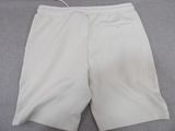 men ' s white shorts on a bed with a white cord