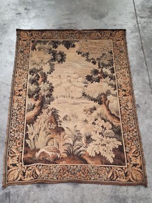 an old rug with a picture of a forest scene on it