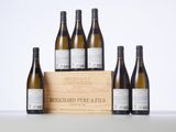 six bottles of white wine in a wooden crate on a table