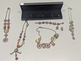 de nombreux bijoux posés sur une table à côté d'une boîte noire